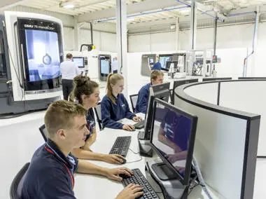 Learners on computers in engineering workshop