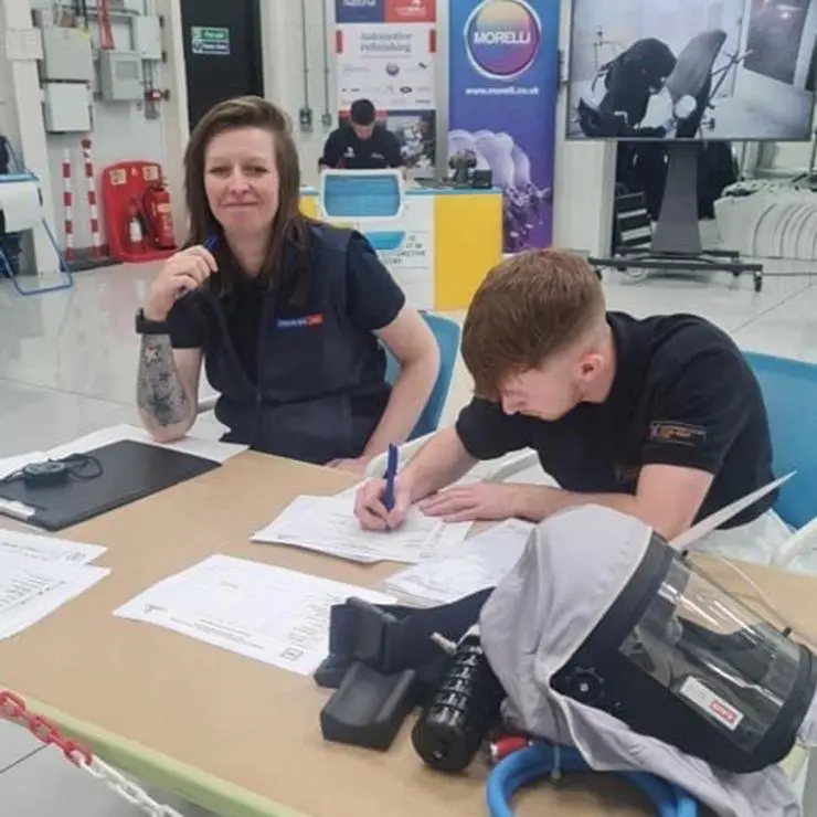 Student sat with tutor overseeing them work