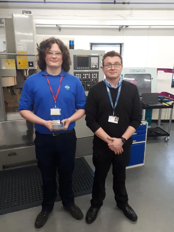 Joseph stood with a tutor in an engineering workshop