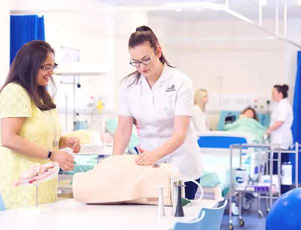 Healthcare student practising under the guidance of a tutor